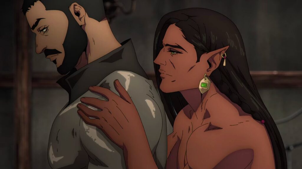 Cena da primeira temporada de Castlevania: Noturno. Olrox (Zahn McClarnon) abraça Mizrak (Aaron Neil) por trás, segurando delicadamente seus ombros. Olrox é um vampiro azteca de pele marrom. Seu cabelo castanho é liso e longo, trançado em uma parte próxima à sua orelha esquerda. Suas orelhas são longas e afiadas, e na sua esquerda podemos ver um pingente dourado com uma pedra verde acorrentado em seu lóbulo, enquanto um brinco dourado e fino, adornado com uma pedra vermelha se pendura na ponta da orelha. Ele não parece vestir nada, e conseguimos ver seu peito nu enquanto ele se aproxima do companheiro. Mizrak é um homem de pele marrom musculoso, com cabelos muito curtos e barba negra, usando uma cota de malha prateada. Ele olha para a esquerda, olhando para o lado oposto de Olrox.