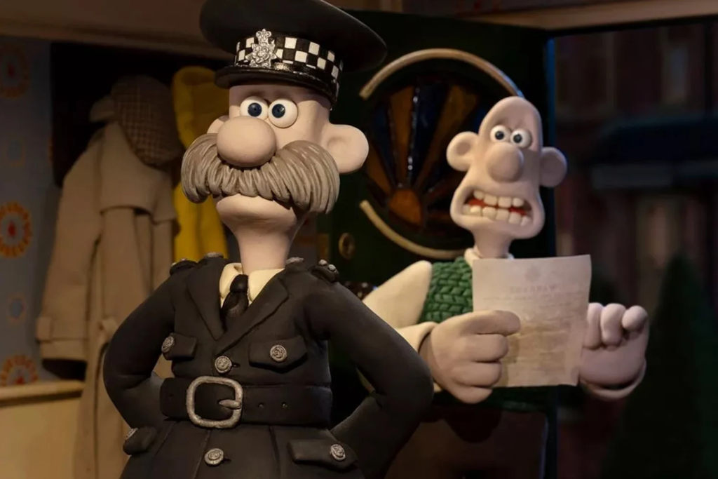 Cena da animação Wallace e Gromit: Avengança. O inspetor Mackintosh entrega a Wallace um mandato de busca para apreender as invenções em sua casa. O inspetor Mackintosh é um homem caucasiano com bigode grande e grisalho, usando um uniforme de polícia preto. Wallace é um homem caucasiano careca que usa um suéter verde sem mangas por cima de uma camisa bege, segurando o mandato entregue pelo inspetor em sua mão direita com expressão de choque. Atrás do inspetor, na parede azul clara, estão alguns itens presos em cabides: um sobretudo claro, uma boina quadriculada marrom e uma capa de chuva. Atrás de Wallace, vemos uma porta aberta dando para a rua. É de noite e o resto da rua está fora de foco. 