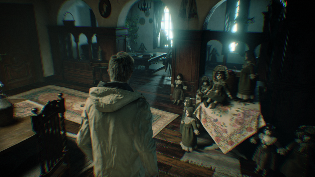 Cena do jogo Resident Evil: Village. Ethan anda por uma mansão coberta por bonecas pequenas viradas para ele. Ethan é um homem caucasiano de cabelos loiros, usando uma jaqueta bege por cima de um moletom escuro. À sua direita, uma mesa de centro coberta por um pano decorado com várias bonecas em cima e ao seu pé. À sua esquerda, uma cadeira em frente à uma mesa de madeira. Em frente à ele, um arco dá entrada para outra parte da mansão, também com bonecas espalhadas pelo chão, com duas janelas semiabertas na parede aposta, fornecendo luz do dia ao cenário.