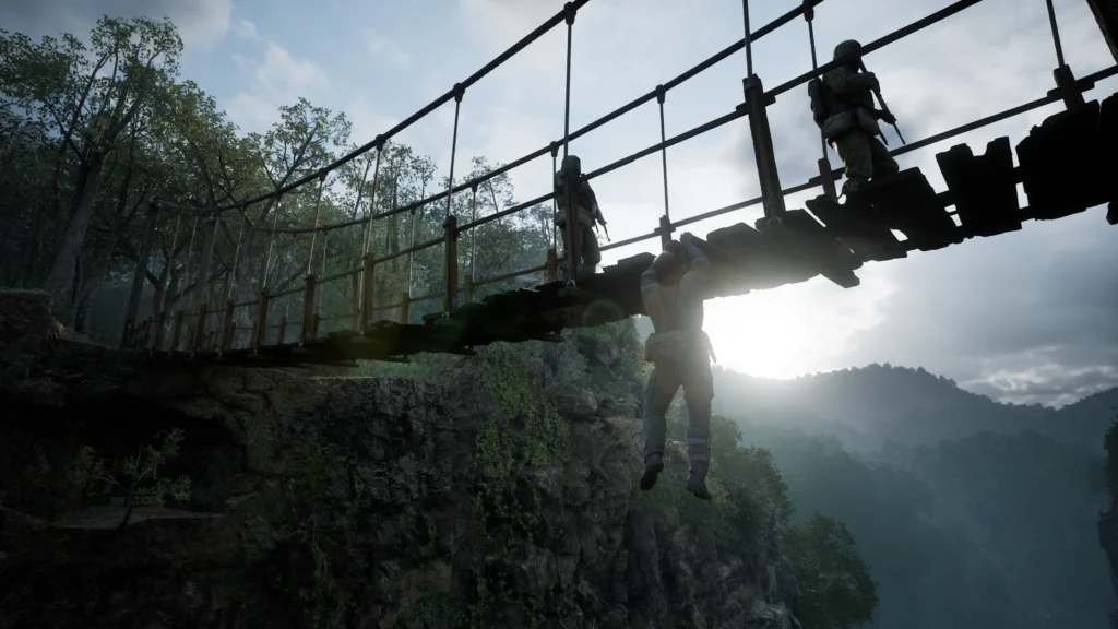Cena do jogo Metal Gear Solid Delta: Snake Eater. Snake se pendura na borda de uma ponte de cordas, esperando dois soldados passarem por ela. Os soldados seguem para a direita e, à esquerda, do outro lado da ponte, vemos uma floresta iluminada pela luz do Sol. Os soldados na ponte vestem roupas verde escuras e carregam rifles nos braços. Pendurado com as duas mãos, Snake possui cabelos castanhos e veste um uniforme militar verde com vários bolsos na cintura. Atrás deles, vemos uma floresta imensa enevoada.
